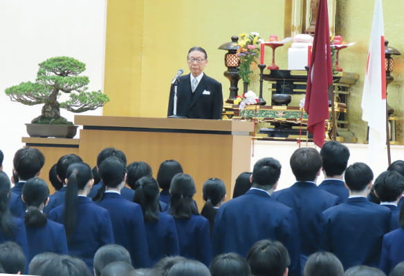式典で学校長の話を聞く生徒